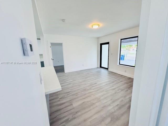 11730 NW 3rd Ave, Miami, FL 33168 - empty room featuring baseboards and wood finished floors
