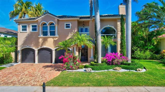 mediterranean / spanish house featuring stucco siding, driveway, a chimney, and a garage