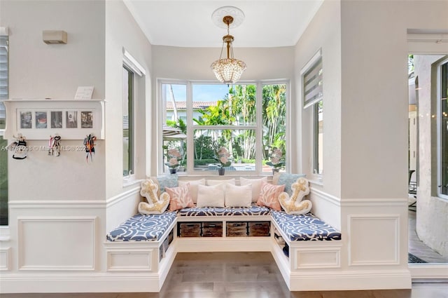 mudroom featuring crown molding, a decorative wall, wood finished floors, and a wainscoted wall