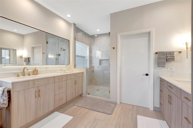 bathroom with vanity, recessed lighting, wood finished floors, and a stall shower