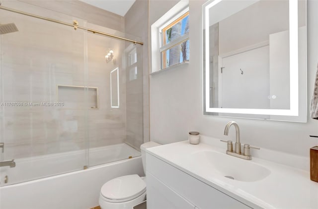 full bathroom featuring combined bath / shower with glass door, toilet, and vanity
