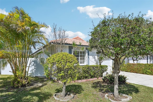 18234 SW 143rd Pl, Miami, FL 33177 - exterior space featuring stucco siding, a lawn, a tile roof, concrete driveway, and a garage
