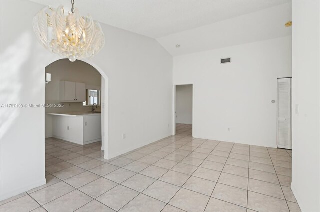 18234 SW 143rd Pl, Miami, FL 33177 - spare room featuring arched walkways, visible vents, an inviting chandelier, and light tile patterned flooring