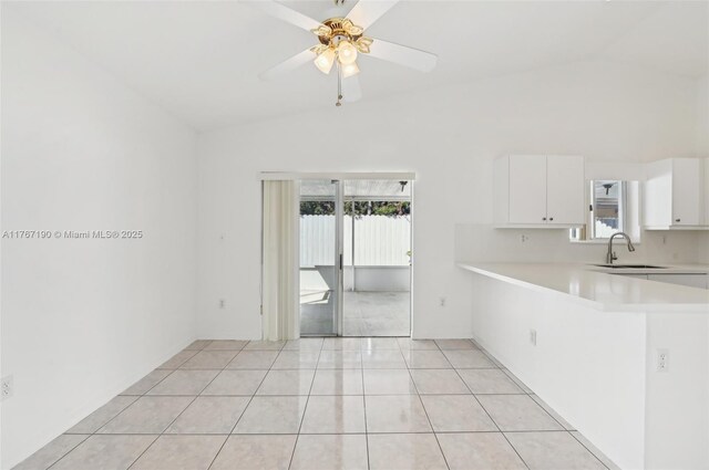 18234 SW 143rd Pl, Miami, FL 33177 - kitchen with light countertops, vaulted ceiling, light tile patterned floors, white cabinetry, and a sink