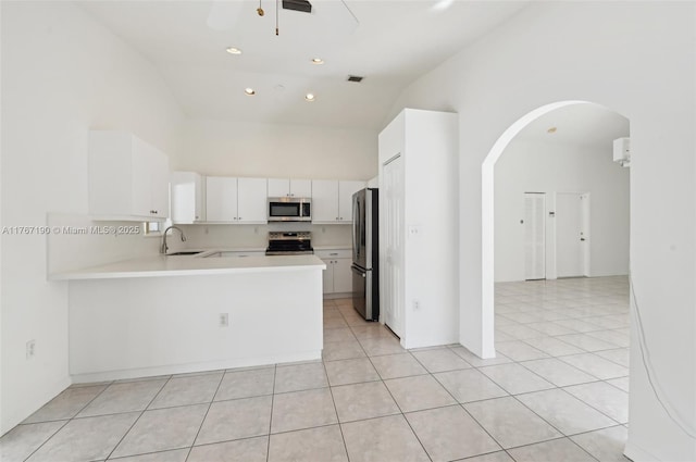 18234 SW 143rd Pl, Miami, FL 33177 - kitchen featuring light countertops, light tile patterned floors, a high ceiling, arched walkways, and stainless steel appliances