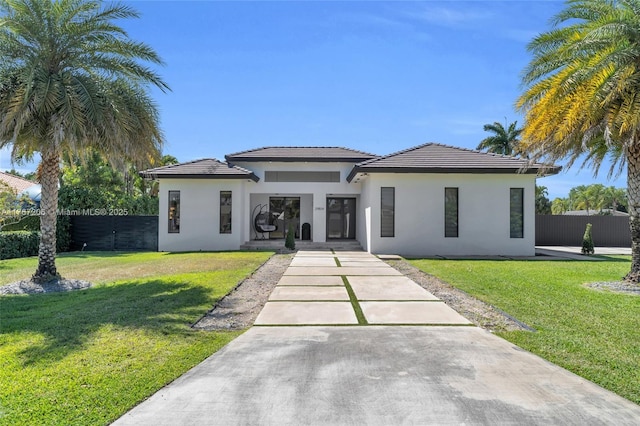 view of front facade featuring stucco siding, a front lawn, and fence