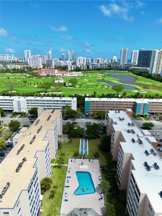 drone / aerial view with a city view, golf course view, and a water view
