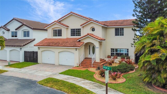 mediterranean / spanish-style house featuring stucco siding, an attached garage, driveway, and a tile roof