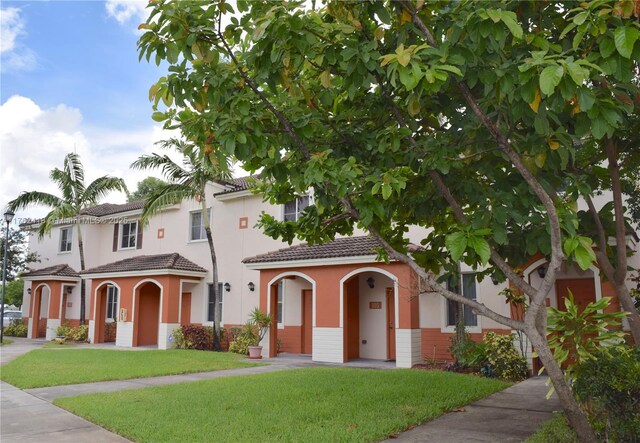 17347 NW 7th Ave Unit 907, Miami Gardens, FL 33169 - mediterranean / spanish-style house with a front yard, a tiled roof, and stucco siding
