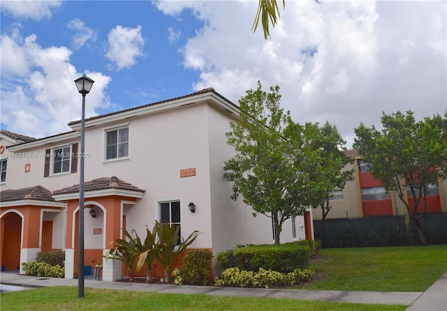 17347 NW 7th Ave Unit 907, Miami Gardens, FL 33169 - view of front of house with a tiled roof, stucco siding, fence, and a front lawn