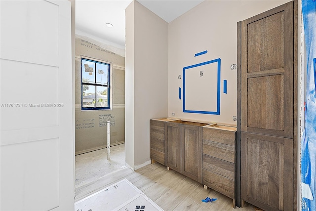 bathroom with wood finished floors, baseboards, and vanity