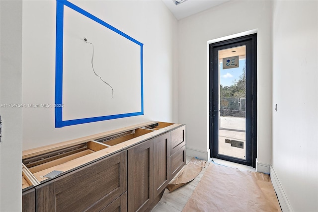 doorway featuring baseboards