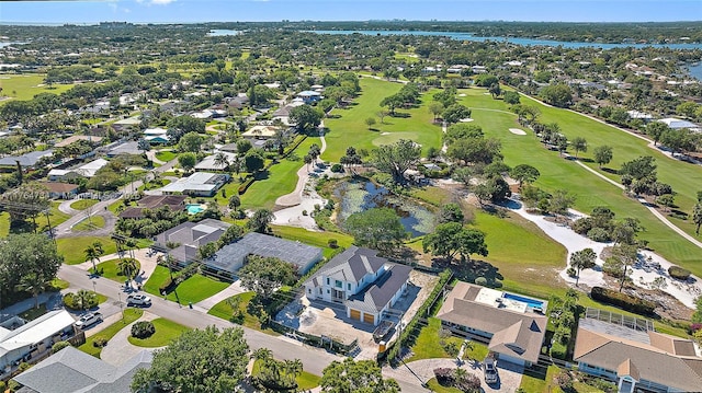 aerial view of property and surrounding area featuring a golf club, a large body of water, and nearby suburban area