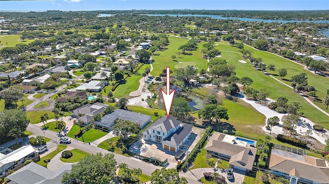aerial view of property's location featuring a golf club, a large body of water, and nearby suburban area