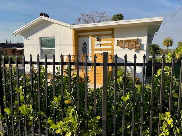 exterior space with a fenced front yard and stucco siding