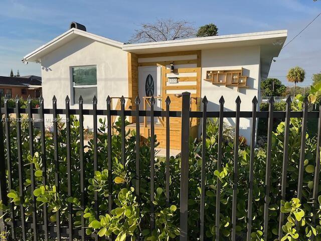 exterior space with stucco siding and fence private yard
