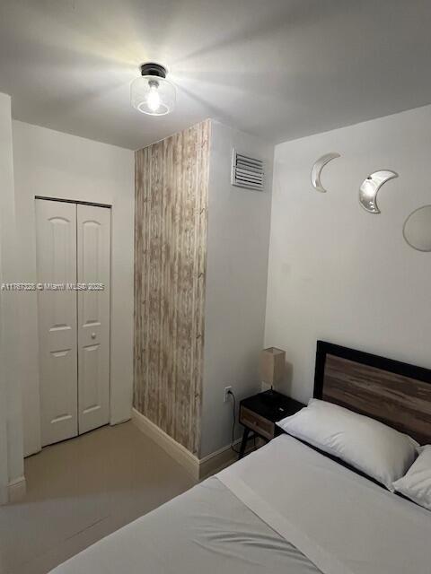 bedroom with a closet, visible vents, and baseboards