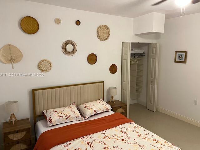 carpeted bedroom with a closet, baseboards, and ceiling fan