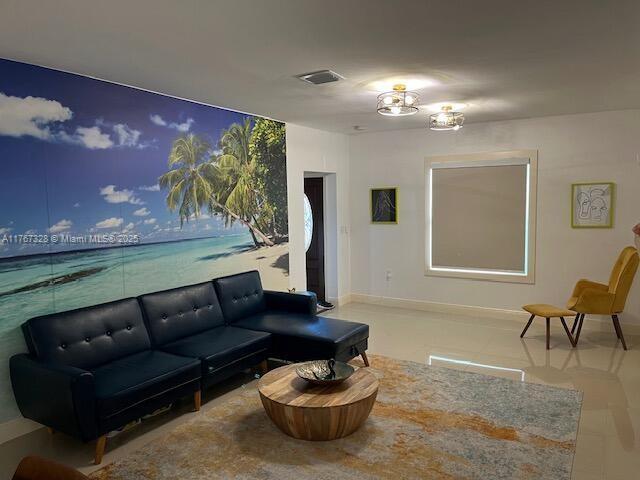 tiled living room featuring baseboards and visible vents
