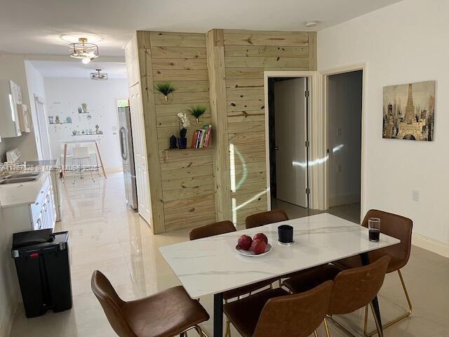 dining space featuring baseboards and wood walls