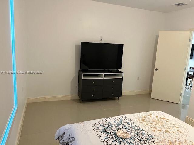 tiled bedroom featuring visible vents and baseboards