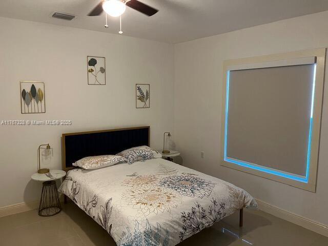 bedroom featuring visible vents, baseboards, and ceiling fan