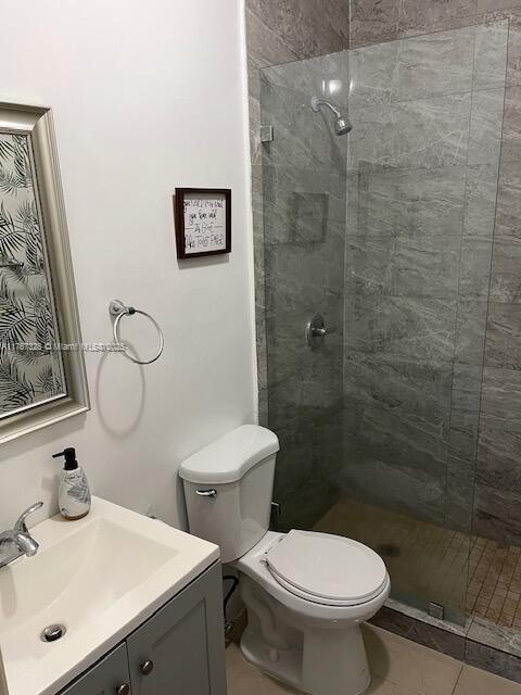 full bath with a shower stall, toilet, and vanity