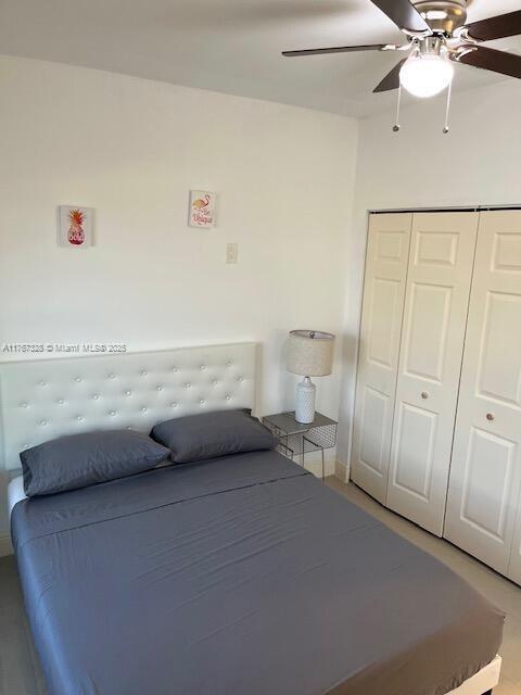 unfurnished bedroom with a ceiling fan and a closet