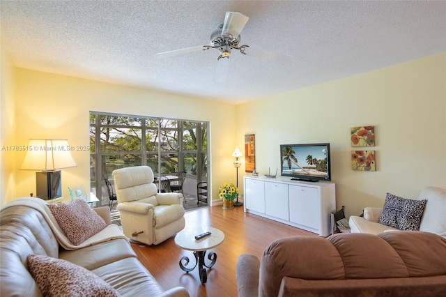 5000 NW 36th St Unit 509, Lauderdale Lakes, FL 33319 - living room featuring a ceiling fan, wood finished floors, and a textured ceiling