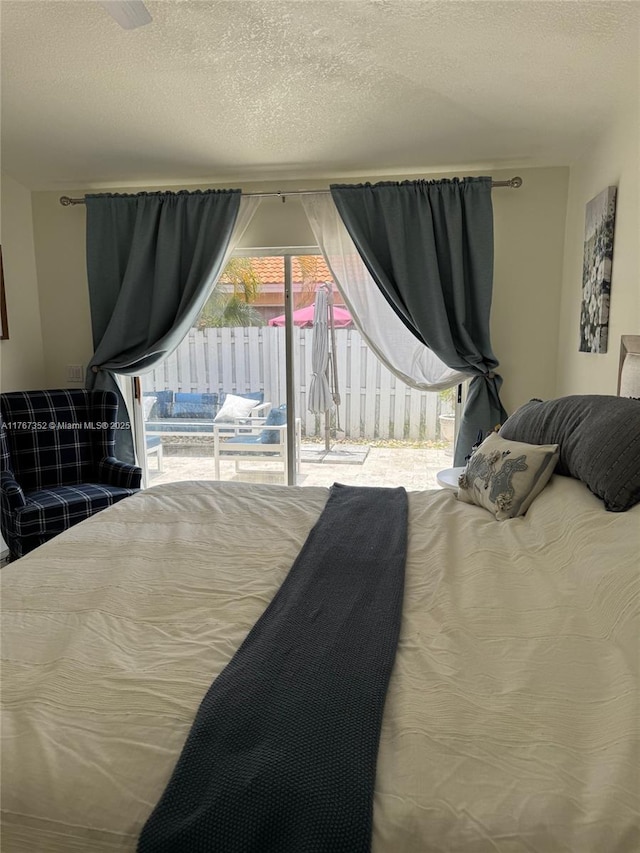 bedroom featuring access to exterior and a textured ceiling