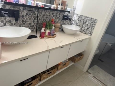 bathroom featuring vanity and tasteful backsplash
