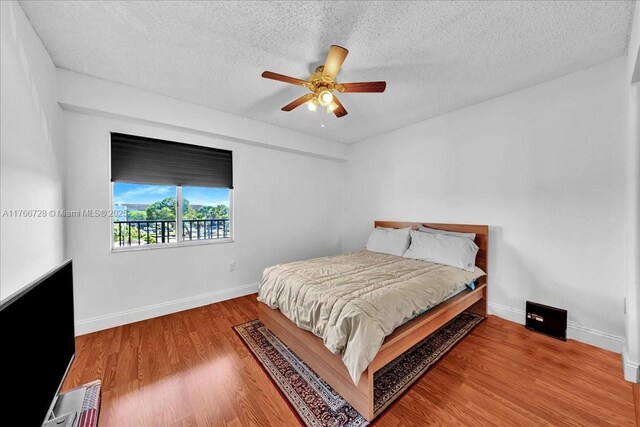 1200 SW 137th Ave Unit 406E, Pembroke Pines, FL 33027 - bedroom with a textured ceiling, wood finished floors, baseboards, and ceiling fan