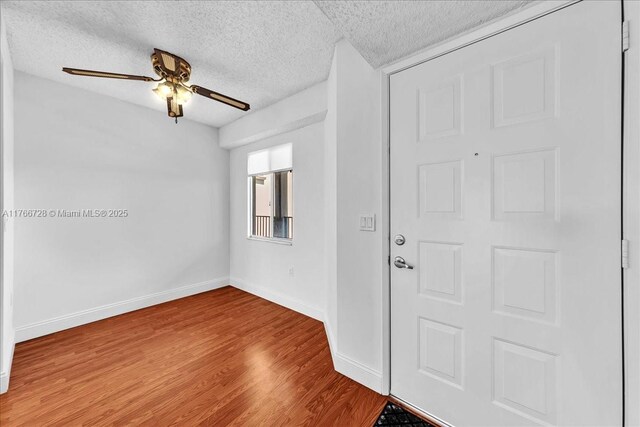 1200 SW 137th Ave Unit 406E, Pembroke Pines, FL 33027 - entrance foyer with a textured ceiling, wood finished floors, baseboards, and a ceiling fan