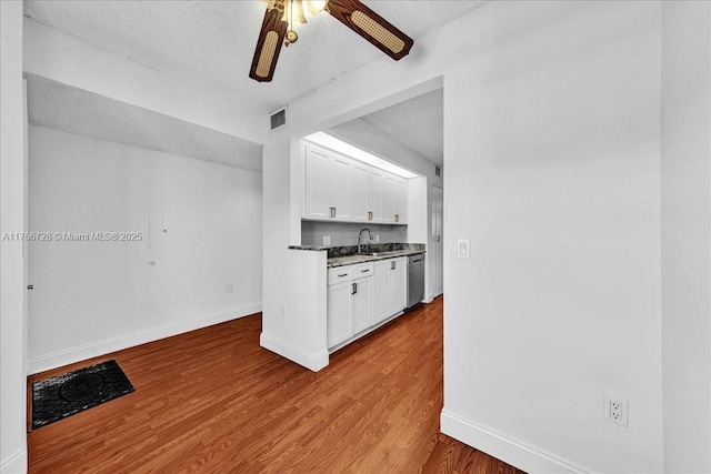 kitchen with dishwasher, white cabinets, wood finished floors, baseboards, and ceiling fan