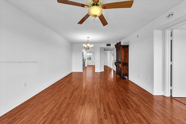 empty room with a chandelier, wood finished floors, a textured ceiling, ceiling fan, and baseboards