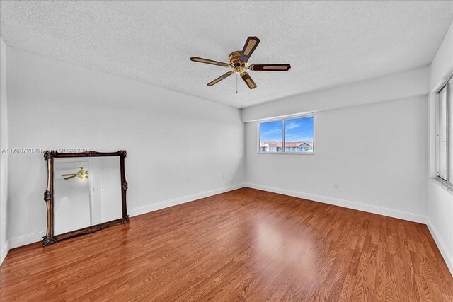 1200 SW 137th Ave Unit 406E, Pembroke Pines, FL 33027 - spare room with a textured ceiling, ceiling fan, wood finished floors, and baseboards