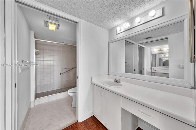 1200 SW 137th Ave Unit 406E, Pembroke Pines, FL 33027 - full bath with a textured ceiling, a stall shower, toilet, vanity, and baseboards