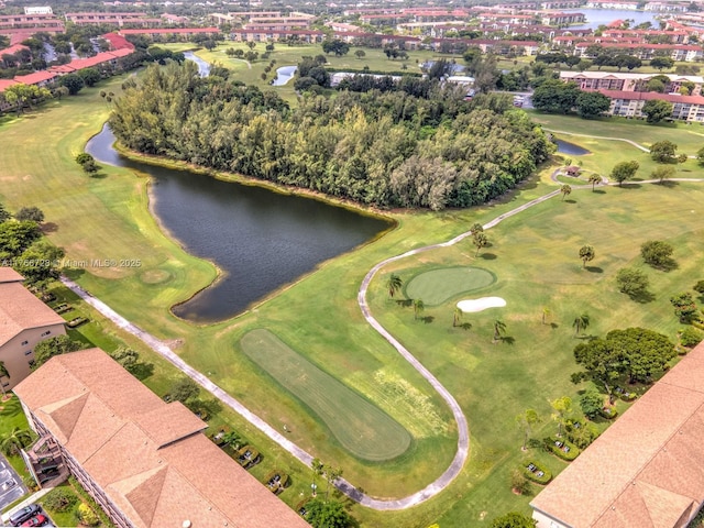 aerial view of property and surrounding area featuring a nearby body of water and a golf club