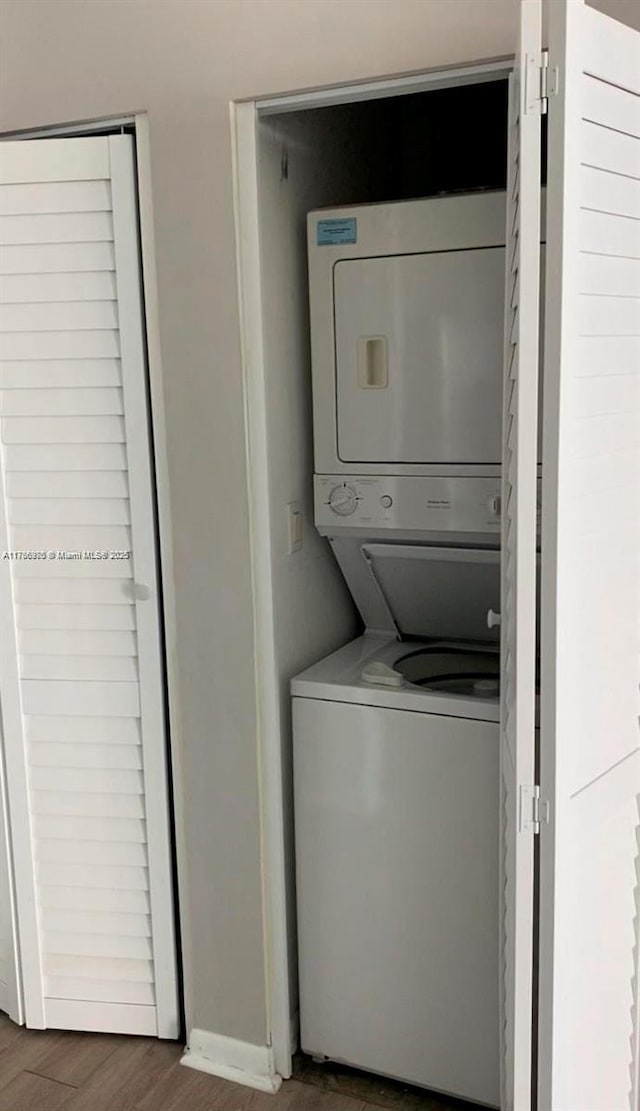 133 NE 2nd Ave Unit 1409, Miami, FL 33132 - laundry area with laundry area, wood finished floors, stacked washer and clothes dryer, and baseboards