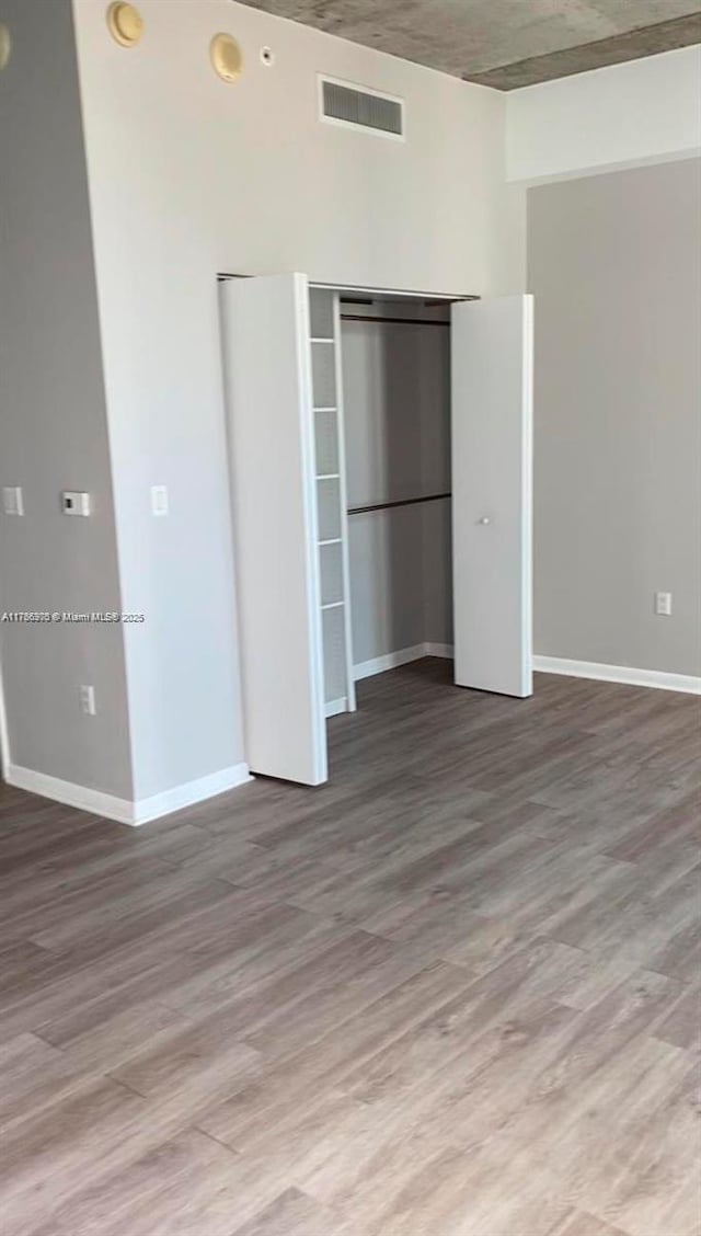 133 NE 2nd Ave Unit 1409, Miami, FL 33132 - unfurnished bedroom with wood finished floors, visible vents, a closet, and baseboards