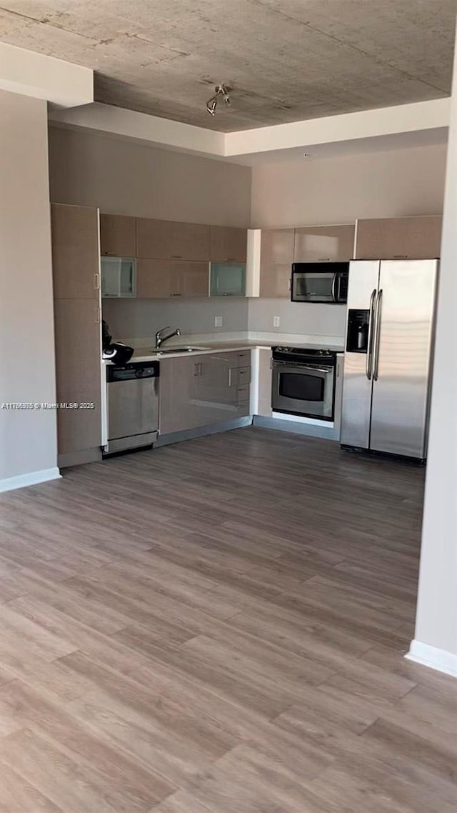 133 NE 2nd Ave Unit 1409, Miami, FL 33132 - kitchen with a sink, wood finished floors, stainless steel appliances, light countertops, and baseboards