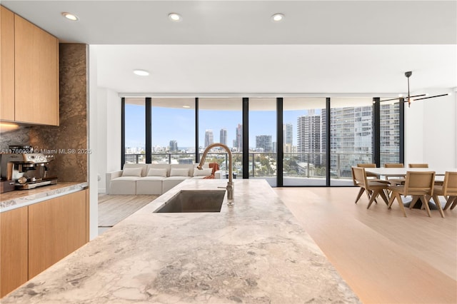 500 Alton Rd Unit 1201, Miami Beach, FL 33139 - kitchen with a view of city, light stone counters, light wood-style floors, and a sink