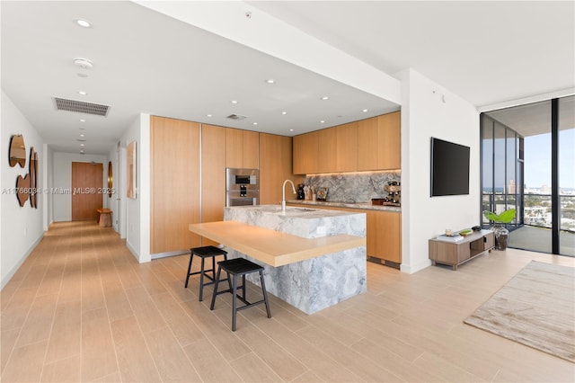 500 Alton Rd Unit 1201, Miami Beach, FL 33139 - kitchen featuring decorative backsplash, a sink, visible vents, modern cabinets, and floor to ceiling windows