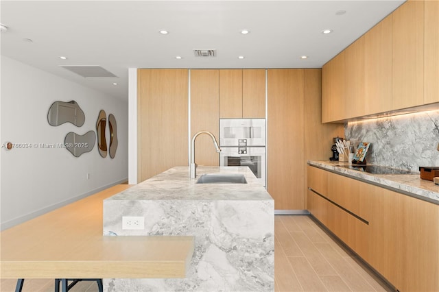 500 Alton Rd Unit 1201, Miami Beach, FL 33139 - kitchen featuring decorative backsplash, black electric stovetop, a sink, recessed lighting, and modern cabinets