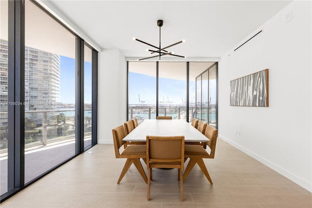 500 Alton Rd Unit 1201, Miami Beach, FL 33139 - dining room with an inviting chandelier, expansive windows, a water view, and light wood-type flooring