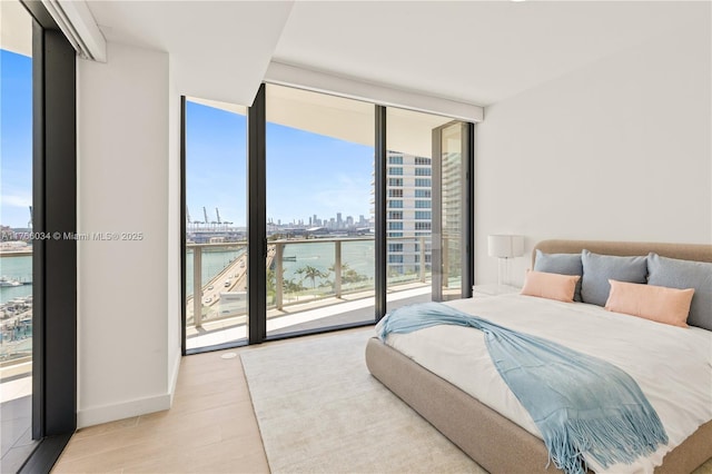 500 Alton Rd Unit 1201, Miami Beach, FL 33139 - bedroom with wood finished floors, expansive windows, access to outside, a water view, and a view of city