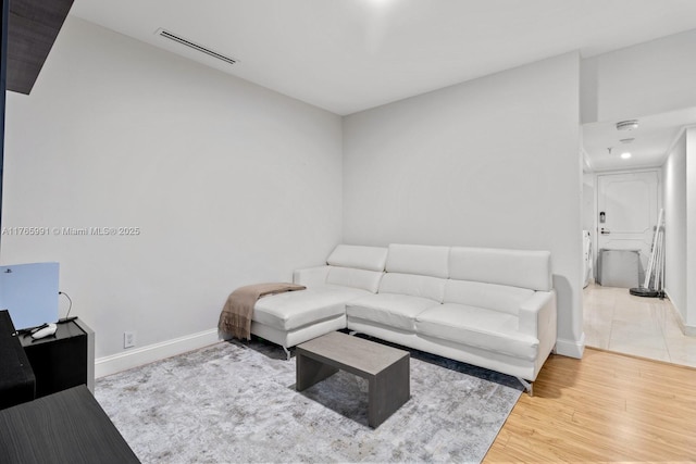 living area featuring baseboards and wood finished floors
