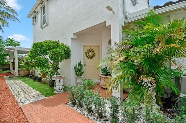 view of exterior entry with stucco siding