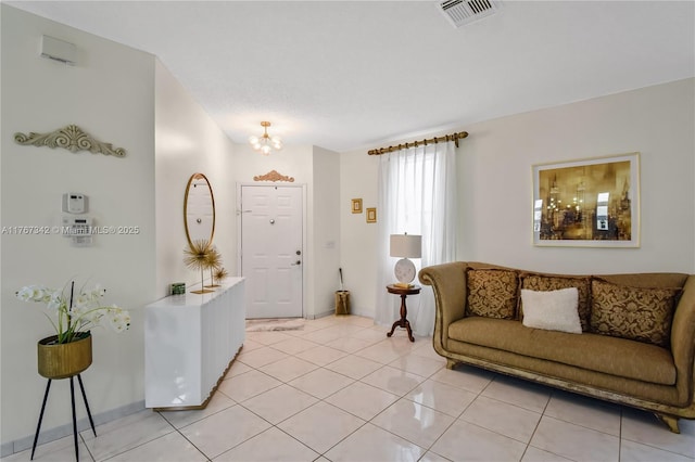 living room featuring light tile patterned floors, baseboards, a notable chandelier, and visible vents