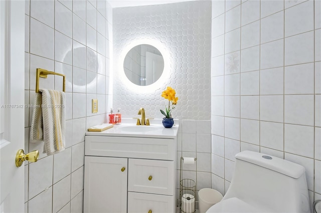 bathroom with tile walls, decorative backsplash, vanity, and toilet
